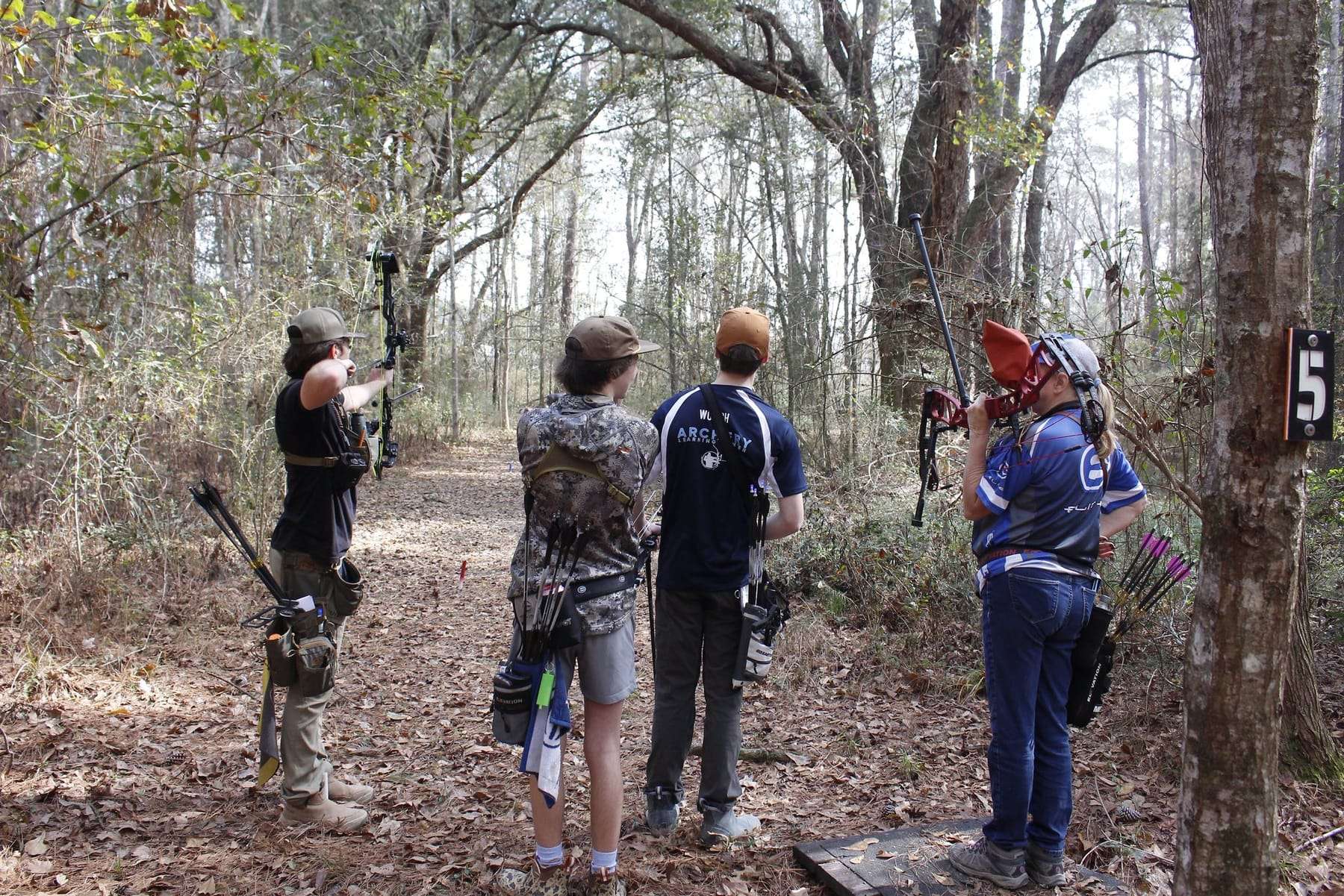 Archers walking a wooded 3D archery course