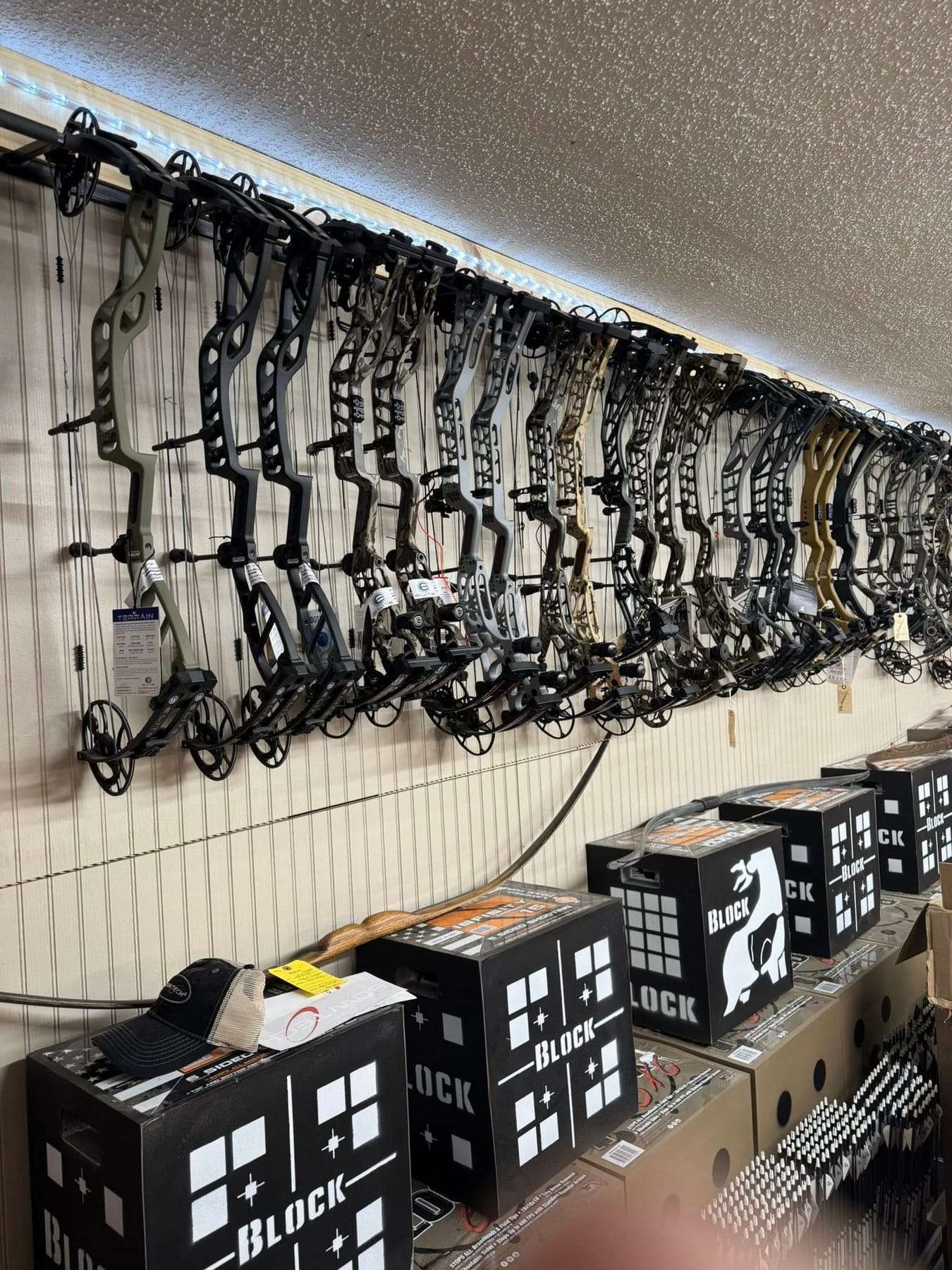 Wall of compound bows and archery targets inside the store