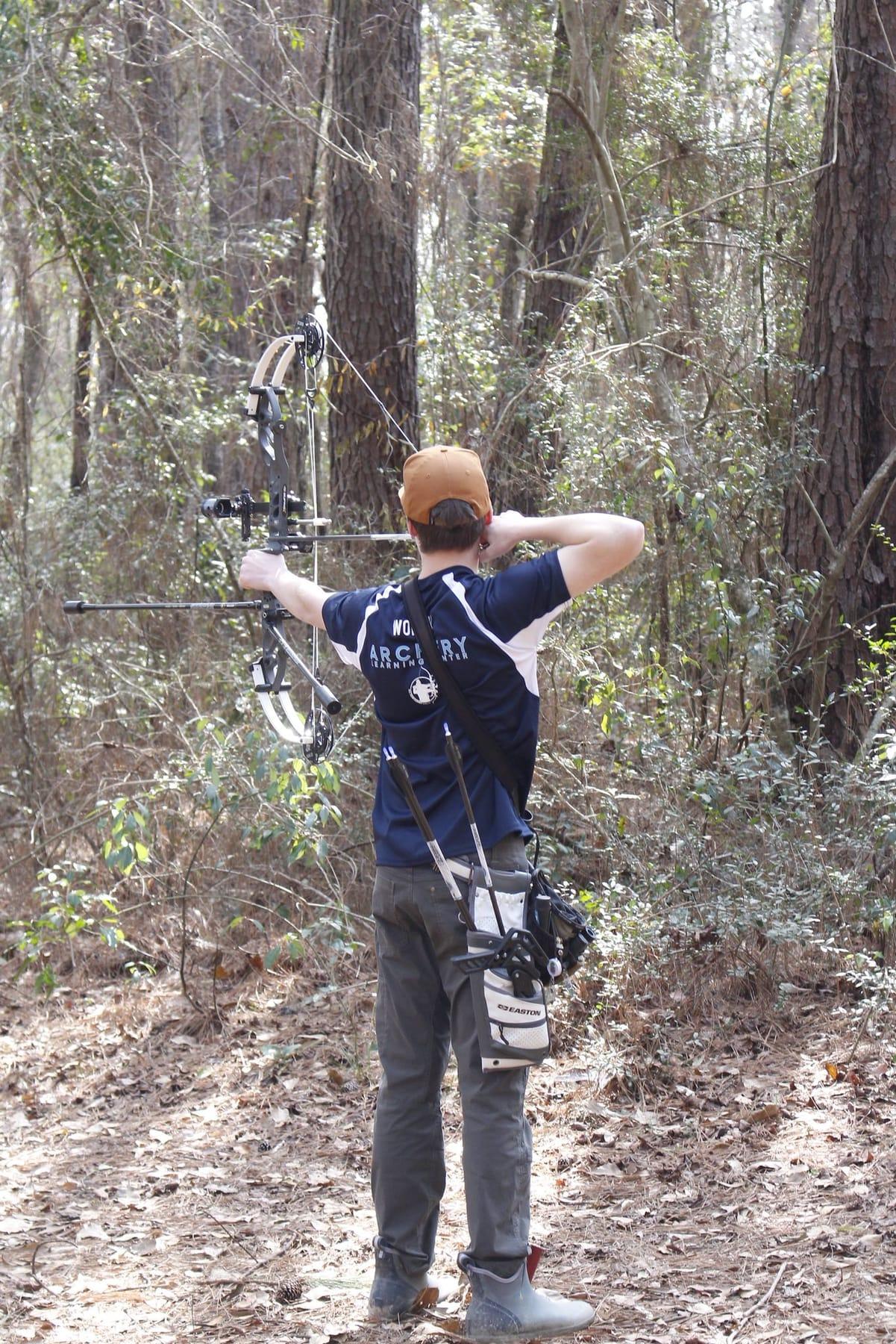 Archer aiming at a 3D target on a woodland archery course