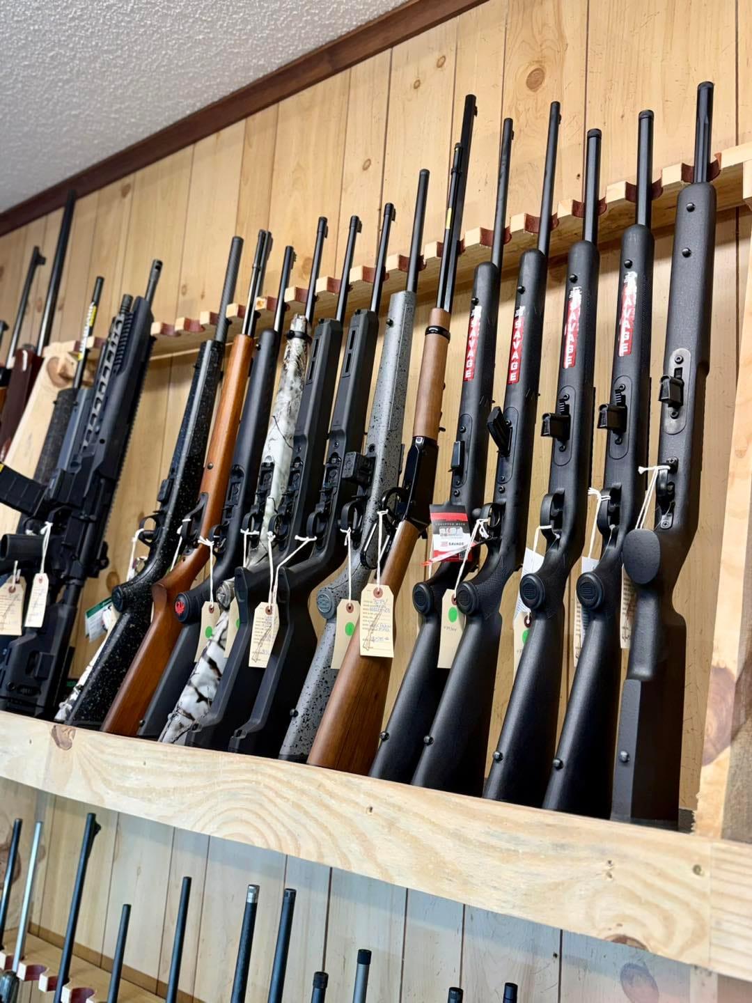 Rifles and shotguns on display on a wooden gun rack