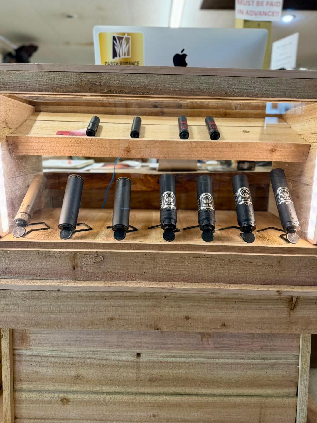 Suppressors on display in a wooden case